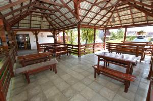 a group of wooden benches in a pavilion at Cris & Mona in Săpânța