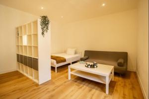 a room with a bed and a couch and a table at Le studio 1900 - Centre-ville in Albertville
