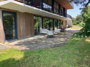 a patio with chairs and tables on a building at Gîte calme et spacieux pour amoureux de la nature in Le Longeron