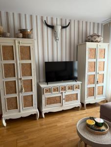 a living room with a tv on top of a cabinet at Apartamento centro de Foz con piscina in Foz