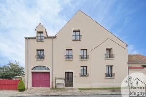 ein großes weißes Haus mit einer roten Garage in der Unterkunft Le Rêve de Fantasia - Enchantement à Disneyland in Magny-le-Hongre