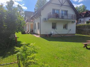 a white house with a yard with a bench at Holiday Home Scamard in Zamárdi
