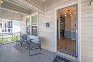 um alpendre com duas cadeiras e uma mesa em Mod Cottage em Wilmington