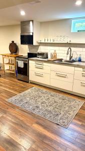 een keuken met witte kasten en een tapijt op de vloer bij Private Apartment Where Remote Work Meets Real Comfort in Oakville