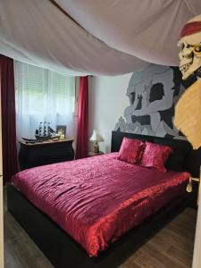 a bedroom with a bed with a skull painting on the wall at Adventure Home Escapade de pirates in Montévrain