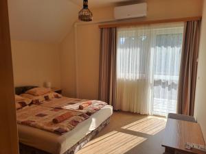 a bedroom with a bed and a large window at Holiday Home Scamard in Zamárdi