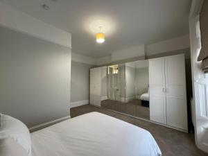 a bedroom with a white bed and a mirror at Charming apartment Belsize Park in London