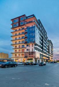 a tall building with cars parked in a parking lot at Mamaia Sea Vibe in Mamaia Sat/Năvodari