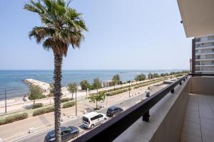 a palm tree on a building with a view of the ocean at Dimora Waterfront in Bari