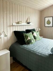 1 dormitorio con 1 cama verde y 2 almohadas en Cozy Summer House Near Kattegat, en Saeby