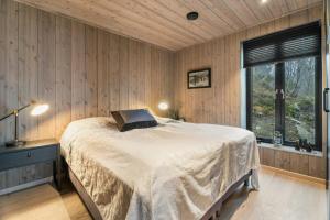 a bedroom with a large bed in a room with wooden walls at Family Cabin At The Foot Of Gaustatoppen in Rjukan