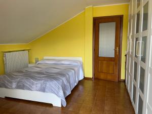a bedroom with a bed and a wooden door at Appartamento Ai Rododendri in Pray