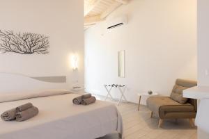 a white bedroom with a bed and a chair at Seaside Home in Posada +58 photos