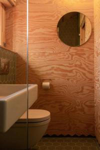 un bagno con un water, un lavandino e uno specchio di Architectural Gem With A View Of Lyngør a Risør Altre 24 foto