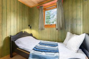 Un dormitorio con una cama en una habitación con ventana. en Enjoy Traditional, Norwegian Cabin Coziness, en Traut