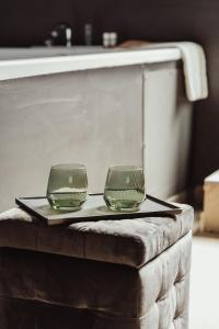dos vasos verdes sentados en una bandeja en una mesa en Cattedrale Suite, en Palermo
