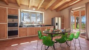eine Küche mit einem Tisch und grünen Stühlen in der Unterkunft Villa Marino in Terranuova Bracciolini