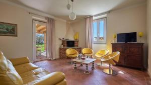ein Wohnzimmer mit gelben Stühlen und einer Couch in der Unterkunft Villa Marino in Terranuova Bracciolini