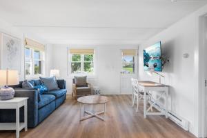 a living room with a blue couch and a table at Marina Bay Cottages in Waterford