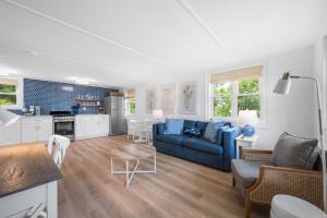 a living room with a blue couch and a kitchen at Marina Bay Cottages in Waterford