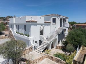 a white house with stairs on a hill at Seaside Home in Posada