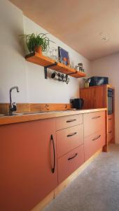 a kitchen with orange cabinets and a sink at Gwynn Lodge in Newquay