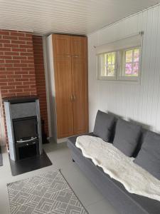 a living room with a couch and a fireplace at Edvin rantamökki in Taalintehdas
