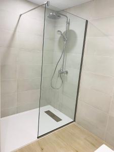 una ducha con puerta de cristal en un baño en Delícies Mar apartamento, en Sant Carles de la Ràpita 7 fotos más