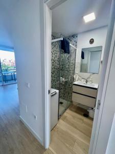 a white bathroom with a sink and a mirror at Stylish and comfortable one bedroom with sea view in Torremolinos