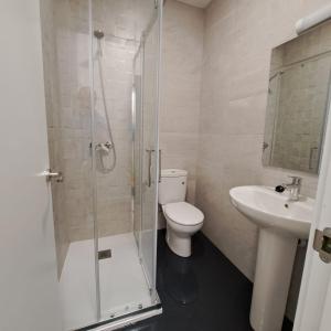 a bathroom with a shower and a toilet and a sink at Miresileón in León