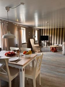 a living room with a table with a bowl of fruit on it at Ferienwohnung Captains Lodge Steinbergkirche in Steinbergkirche