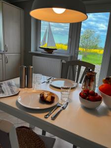 a table with a plate of food and a boat in a window at Ferienwohnung Captains Lodge Steinbergkirche in Steinbergkirche
