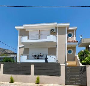 a white house with a balcony with two dogs on it at Vei Estate in Schinias