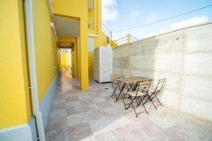a patio with a table and chairs on a yellow wall at Casa Amarela in Encarnação