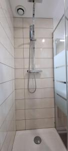 une douche avec une porte vitrée dans une salle de bain dans l'établissement Studio proche Capitole - Terrasse - Wifi - TV, à Toulouse