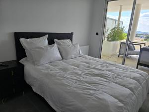 a bed with white sheets and pillows in a bedroom at CS Skyline rooftop spa de nage in Montpellier +40 photos