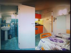 a room with a bed and a bathroom with a sink at Casa Blu with Sea View - Borgo Stays in Sperlonga