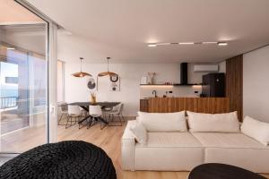 a living room with a white couch and a table at Sea Flow - Luxury seafront Penthouse at Psani Beach in Nafpaktos