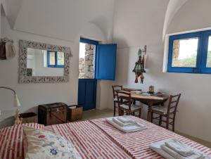 a bedroom with a bed and a table with chairs at Dammusi Musa in Pantelleria