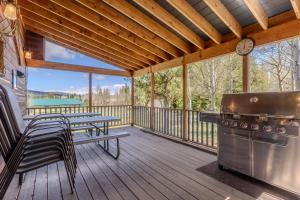 a screened in porch with a grill and tables and chairs at Blue Spruce Cabin in West Yellowstone