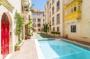 an apartment with a swimming pool in a building at Ix-Xaluppa J3 Apartment Gozo in Malta