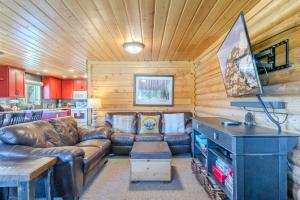 a living room with a leather couch and a table at Blue Spruce Cabin in West Yellowstone