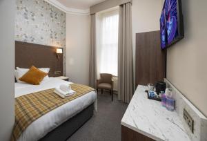 a hotel room with a bed and a tv on the wall at Albany Hotel in Edinburgh