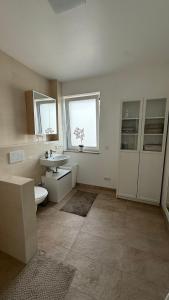 Traum-Ferienwohnung über 2 Etagen mit Sonnenterasse und Seenähe في زولبيتش: حمام أبيض مع حوض ومرحاض