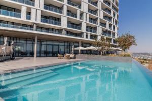 a swimming pool in front of a building at Hospitality at Waterfall City - Ellipse Waterfall in Midrand