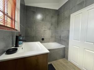 a bathroom with a sink and a bath tub at ACORN STUDIO Fully equipped Studio with kids loft in Durban