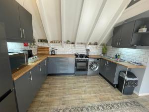 a kitchen with blue cabinets and a washing machine at ACORN STUDIO Fully equipped Studio with kids loft in Durban +11 photos