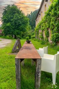 einen Holztisch und zwei weiße Stühle auf dem Gras in der Unterkunft Design Apartment In The Historic Mittermurnthal in Neunburg vorm Wald