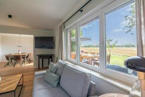 Una sala de estar con un sofá y una ventana grande. en Country House Close To The Beach With Field Views, en Maasholm