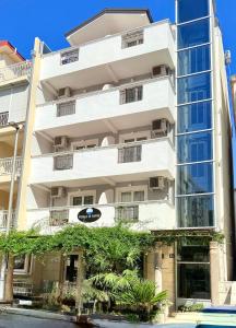 a white building with trees in front of it at Hotel Villa Perla Di Mare in Budva